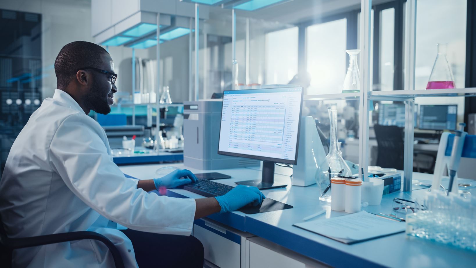 Un technicien de laboratoire travaille sur un système informatique doté du système SDMS (Scientific Data Management System) de STARLIMS.
